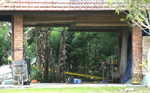 Police tape behind the car garage where the cannabis plants were allegedly found.