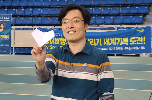 Shin Moo Joon holding up the paper plane.