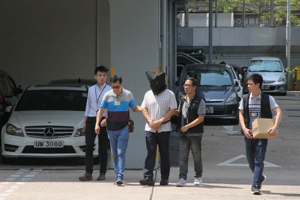 Khaw (middle) being escorted by the police after his arrest in 2017.