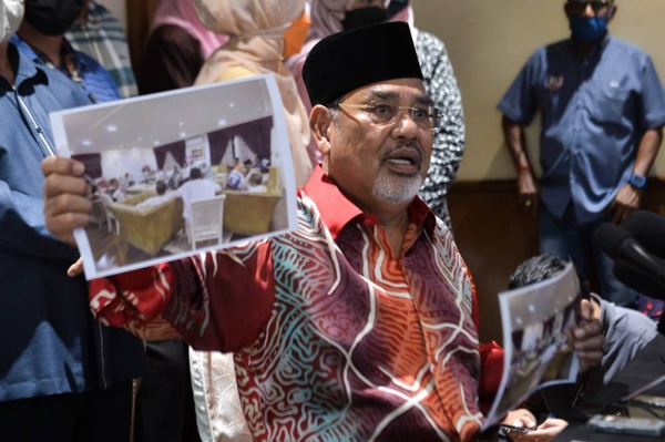 Tajuddin showing a photo of a secret meeting with party members held at his house.