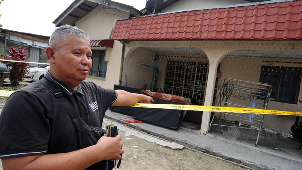 The 26-year-old victim's father, Rosman Ahmad, at the scene of the crime in Kampung Bakar Batu.