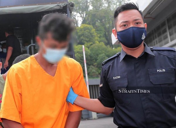 Police escorting the 24-year-old suspect to the Johor Bahru Magistrate's Court on Tuesday, 5 July.