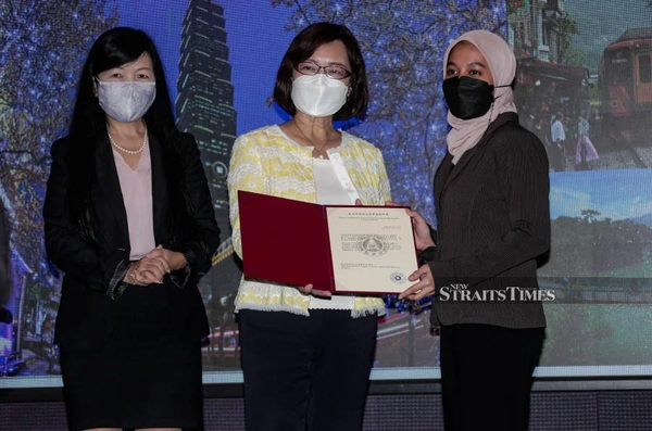 Anne Hung, the representative of the Taipei Economic and Cultural Office in Malaysia, (centre) presenting a scholarship certificate to Nor Ain Daniella Abdul Samad yesterday, 25 July.