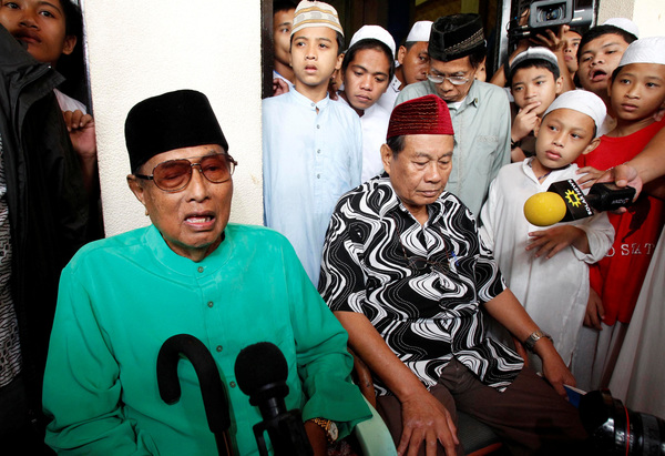 Jamalul Kiram III answers questions as he sits surrounded by his followers, during a brief news conference in front of the Blue Mosque in Taguig city, south of Manila on 22 February 2013.