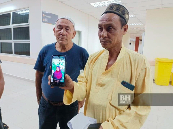 M Nor Zawawi showing a photo of his daughter, Nur Asyqin Qistina, at the Gua Musang Hospital on Monday, 15 August.