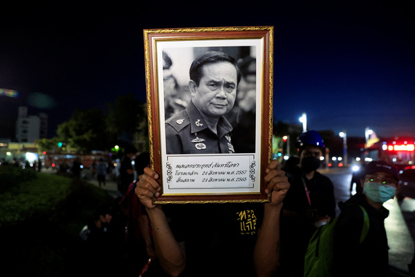 A person holds up a picture of Prime Minister Prayuth Chan-ocha during a protest.