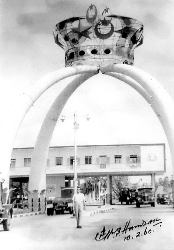 Mohamed taking a photo with the archway designed by him at Tambak, Johor.