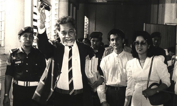 Karpal Singh waving to his friends after leaving the courtroom with his wife and son in 1989.