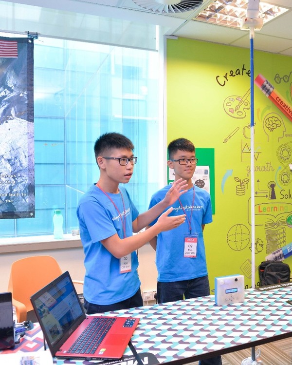 Kok Wei (on the right) and his project partner explaining how the Snap King device works.