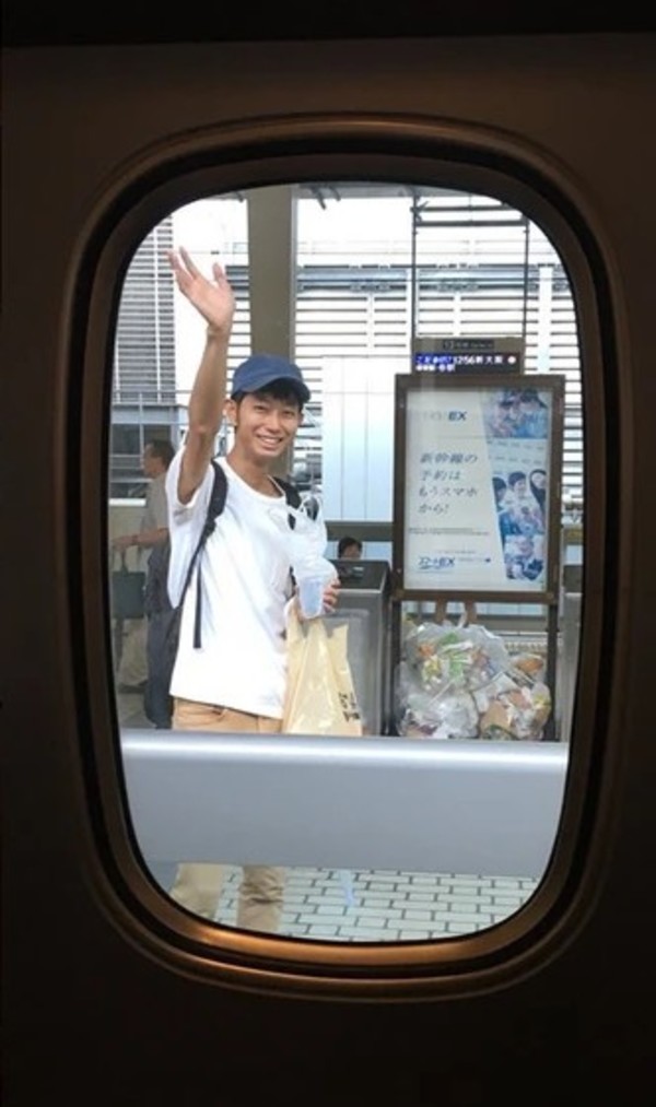 Shoji Morimoto waving goodbye to his client who wanted a send-off at a train station.