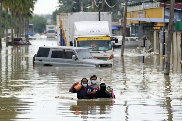 A photo of residents in Shah Alam wading through a flood in 2021.