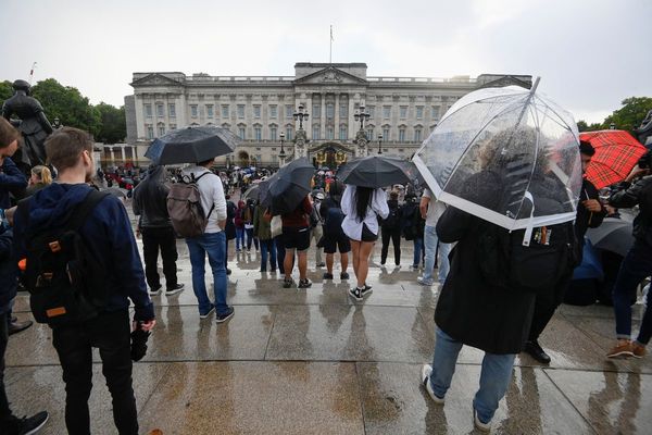 People shelter under their umbrellas as they gather outside Buckingham Palace, following a statement from the Palace over concerns for Britain's Queen Elizabeth's health, in London, UK.