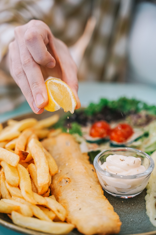 Fish and chips served with a side of salad and fries.