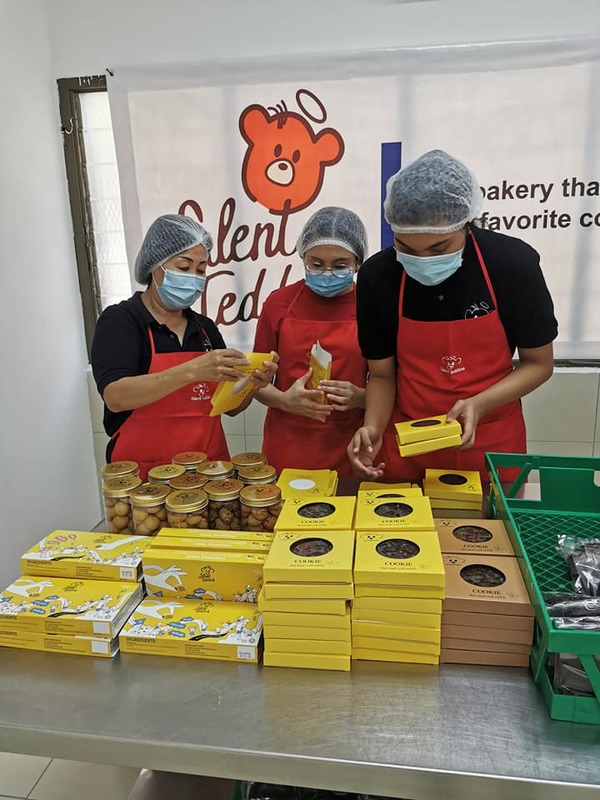 Leong helping package baked goods that were made by the Deaf employees at Silent Teddies Bakery.