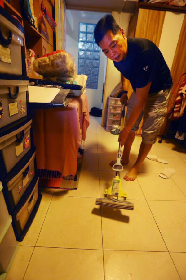 Liu demonstrating himself mopping up the condensation off his apartment's floor.