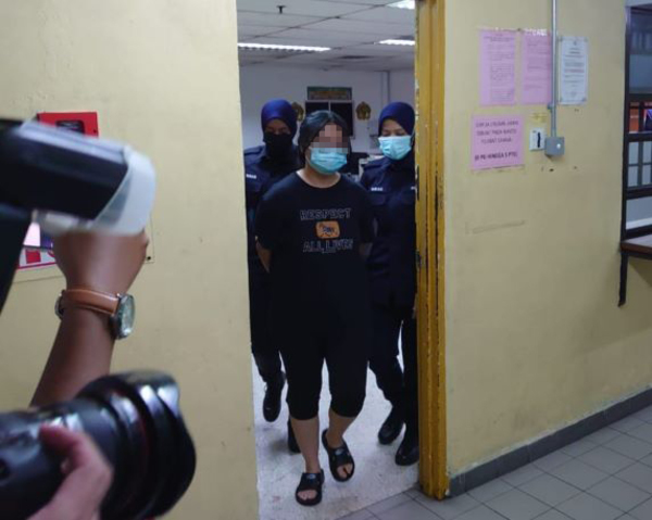 Sim being brought to the Johor Bahru Magistrate's Court.