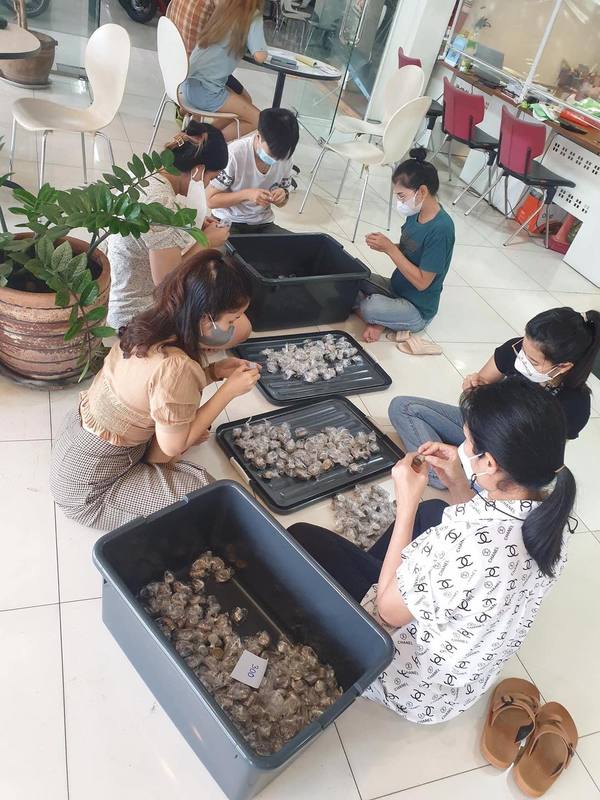 The employees of Akhom Charoen Honda Motorcycles counting coins for the purchase of the Honda PCX160.