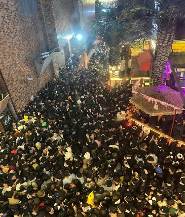 The photo shows a sea of people packed inside the alley, jostling against each other in their attempt to find space.