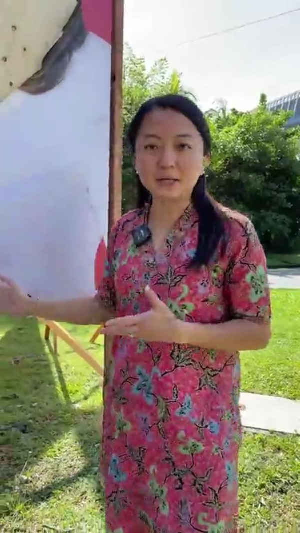 Yeoh in front of a damaged billboard in TTDI.