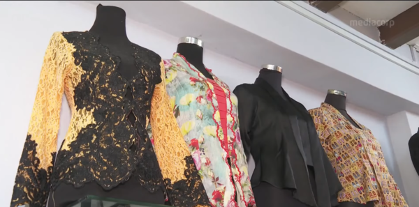 A collection of baju kebaya at a batik cloth shop.