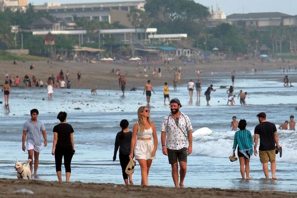 A photo of tourists walking on the beach in Badung, Bali post-pandemic in 2021.