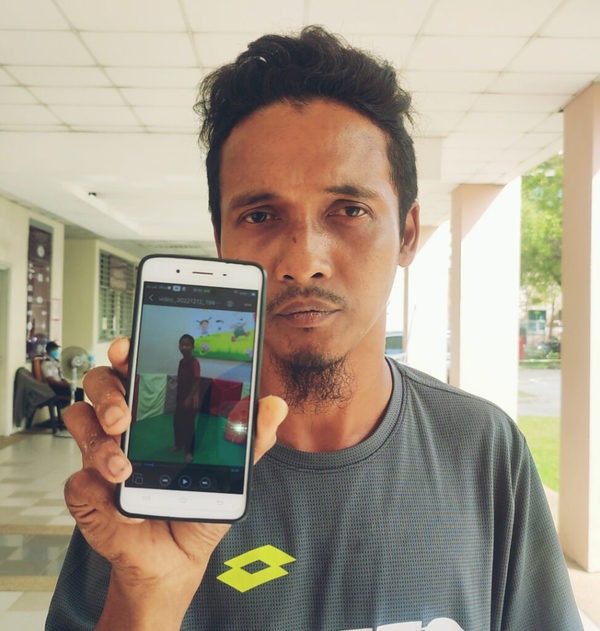 Suhaimi Hassan showing a picture of his son Muhammad Khairul Muhaimin.