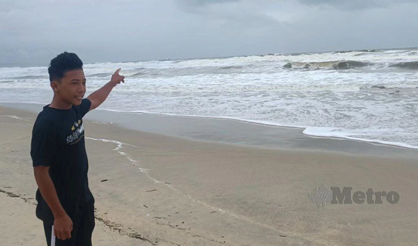 Muhammad Zulfikal Asmadi showing the beach where he saved a girl from drowning.