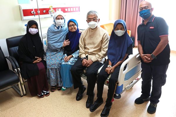 Sultan Abdullah (centre) and Tunku Azizah (second from left) posing for a picture with Mya Zara (third from left) and her family, her father Faizal Jamaluddin (third from right), her sister Myra Qistina Faizal (second from right) and her mother Murniewatie Bawok (third from right).