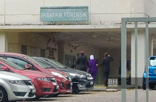 The photo shows two prison guards bringing the mother to the morgue to see her child.