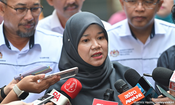 File photo of Education Minister Fadhlina Sidek, seen talking to reporters, while ministry officials look on.