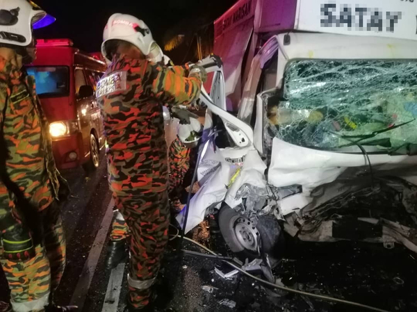 The photo shows firemen trying to open the lorry's driver-side door.