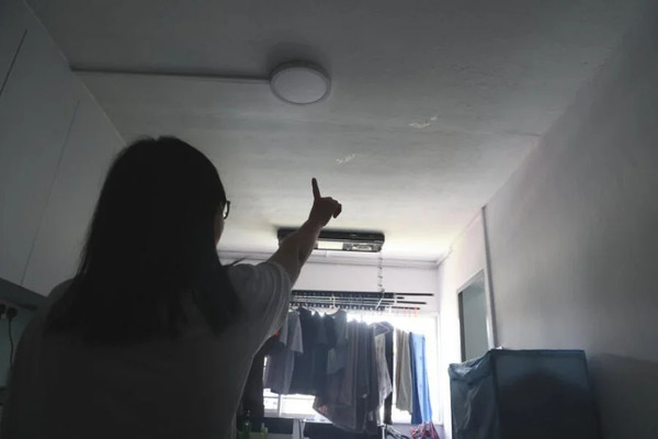 Chen pointing out the leak in the kitchen ceiling after learning that the previous owner had died in the unit.