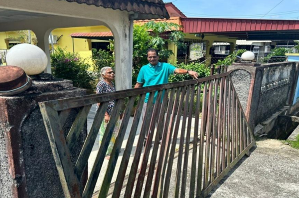 M Pavayee Ammah in front of her house.