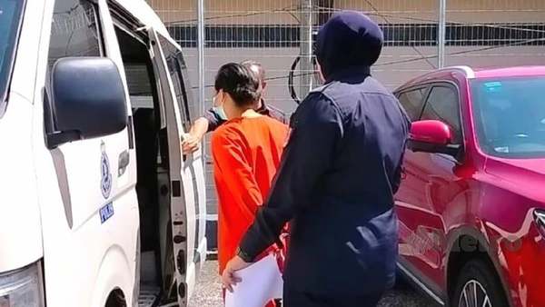 Syarra Sudarman being escorted at the Kuala Pilah Magistrate's Court.