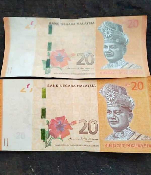 The counterfeit RM20 note (top) compared to a real RM20 banknote (bottom).