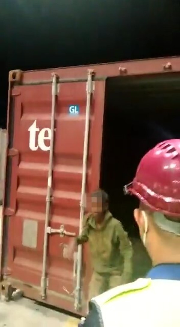 The teenager walking out of the shipment container he was trapped in.