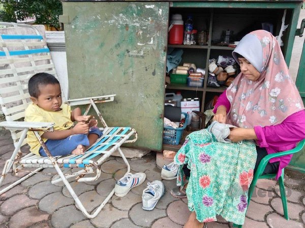 Norhayati sewing shoes at her workshop.