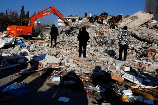 Civilians looking upon the remains of a destroyed building in Kahramanmaras, Turkiye.