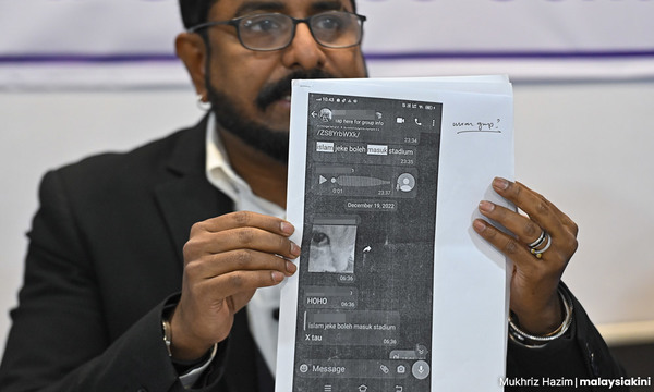 Hindu Agamam Ani Malaysia Association chairperson Arun Dorasamy holding up printed copies of the WhatsApp conversations.