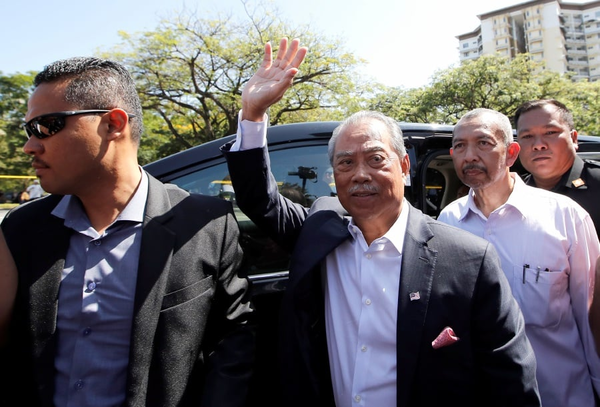 Muhyiddin waving to reporters after arriving at the MACC headquarters today, 9 March.