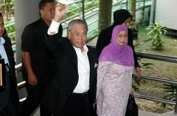 Muhyiddin diiringi isteri, Puan Sri Norainee Abdul Rahman ketika hadir ke mahkamah bagi menghadapi pertuduhan di Mahkamah Sesyen Shah Alam.