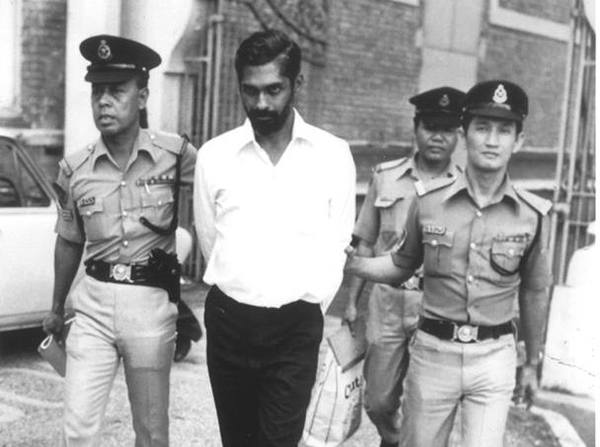 Karthigesu being escorted by the police in front of the courthouse in 1979.