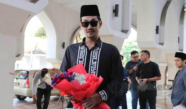 Farid Kamil at the courthouse with the bouquet of flowers.