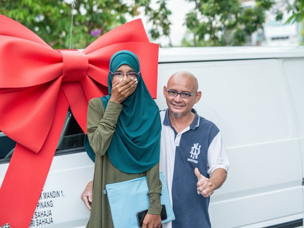 Kak Ina and her husband after she was gifted a van.