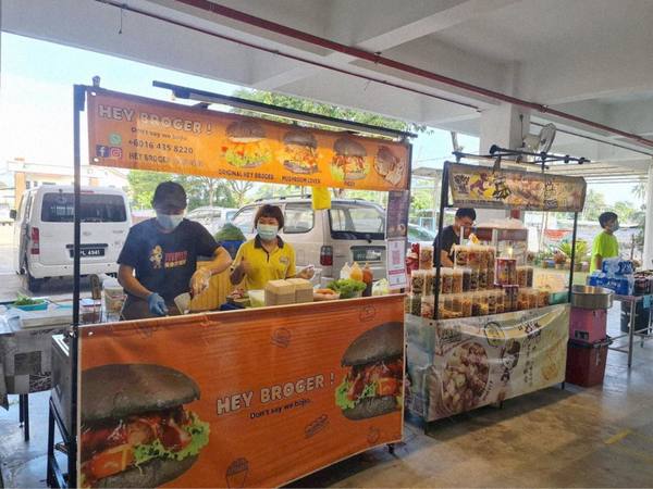 Everlyn with her son at his burger stall, next to which is her popcorn stall.