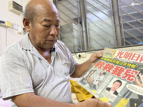 Cheong Kah Pin showing a newspaper headline about his visit to Singapore's Istana, the office of the President, to kneel down and beg for mercy.