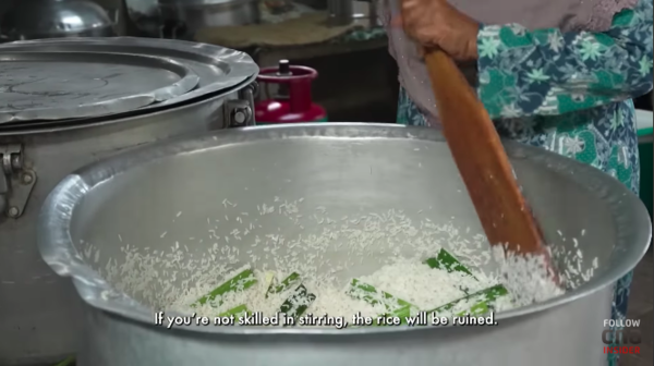 Kak Salehah showing Tan how to make coconut rice for nasi lemak.