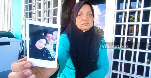 Nuralifah's mother, Salmah Idrus, showing a photo of the couple.