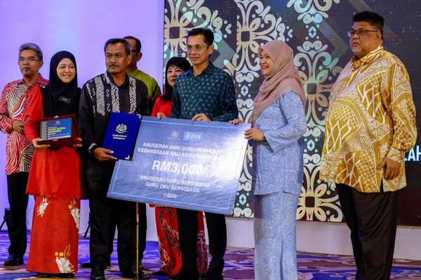 Jasmi Md Tegol (third from left) receiving the Competent Teacher Award presented by Education Minister Fadhlina Sidek (second from right) at the 2023 Teachers' Day Award Ceremony.