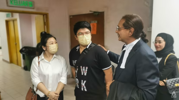 Braden Yap Hong Sheng (centre) and his lawyer GK Sritharan (right) outside the Johor Bahru Sessions Court.